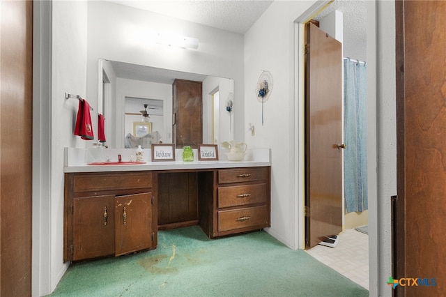 full bath featuring carpet, vanity, a textured ceiling, and a shower with shower curtain
