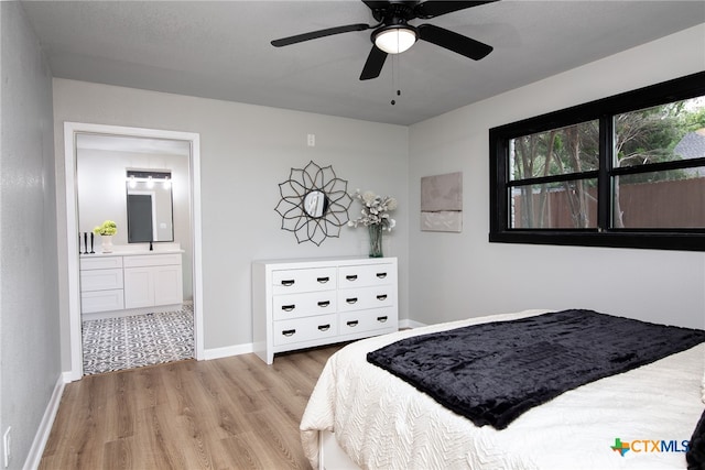 bedroom with connected bathroom, ceiling fan, and light hardwood / wood-style flooring