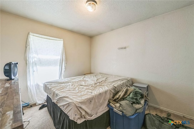 bedroom with a textured ceiling, a textured wall, and carpet