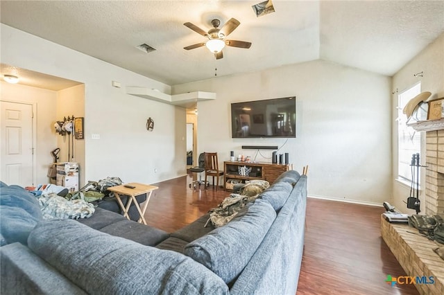 living area with a textured ceiling, a ceiling fan, visible vents, lofted ceiling, and wood finished floors