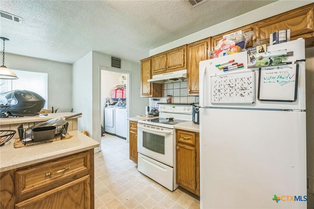 kitchen with under cabinet range hood, white appliances, light countertops, and brown cabinetry