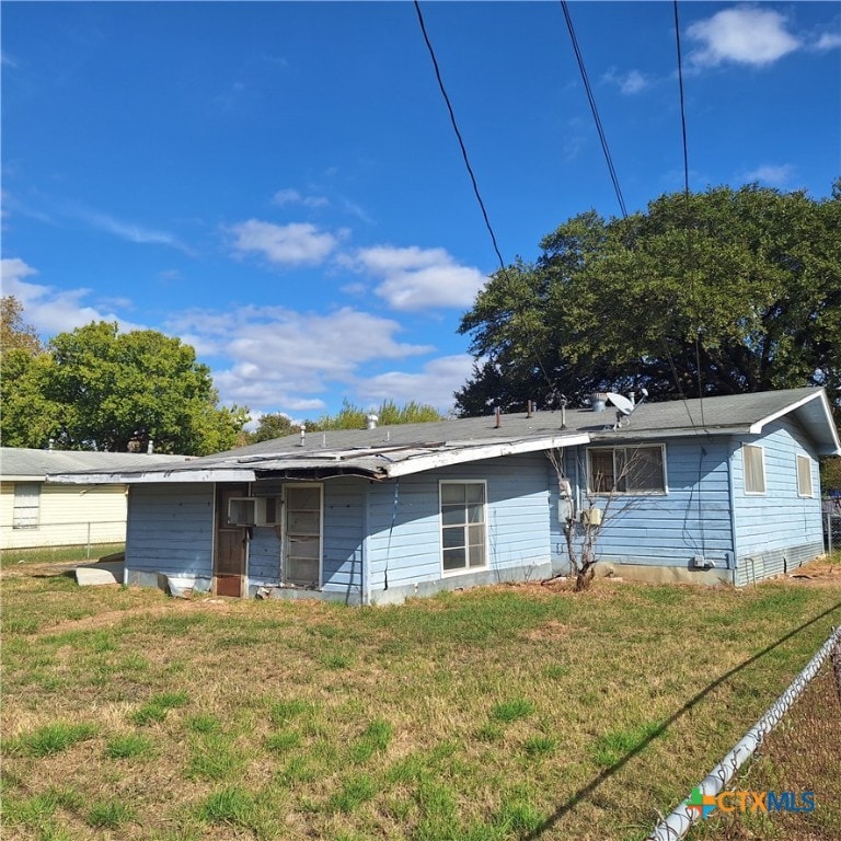 rear view of property featuring a yard