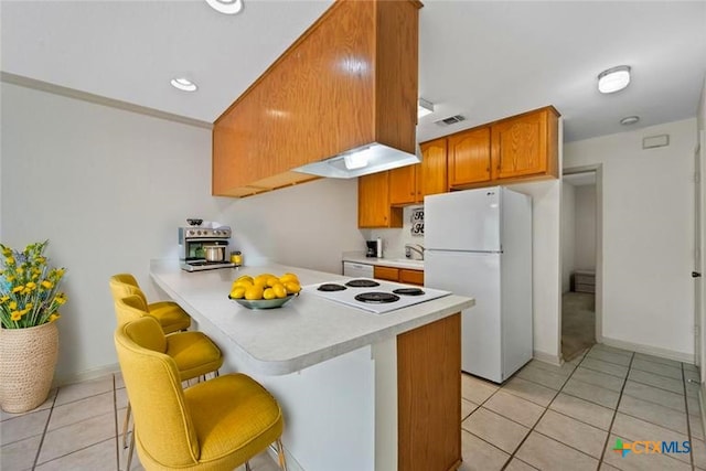 365 S Gilbert Ave, New Braunfels, TX 78130 - kitchen with white appliances, light countertops, a peninsula, light tile patterned floors, and a kitchen breakfast bar