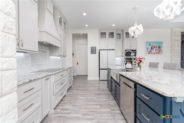 kitchen featuring white cabinetry, stainless steel dishwasher, custom exhaust hood, and blue cabinets