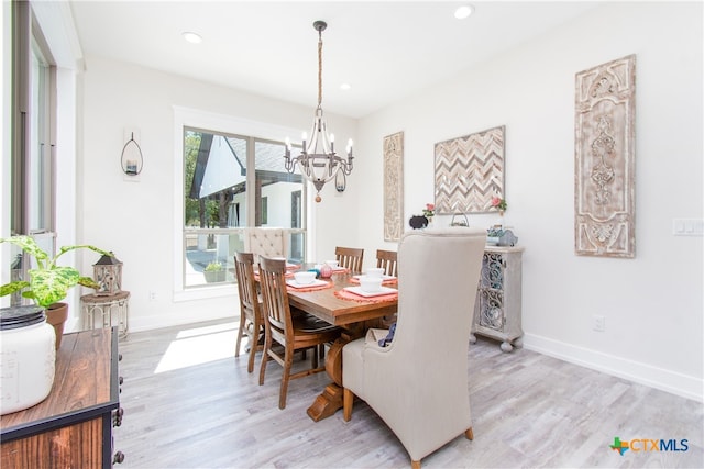 dining area featuring an inviting chandelier and light hardwood / wood-style floors