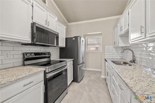 kitchen with light stone counters, a sink, white cabinets, appliances with stainless steel finishes, and crown molding