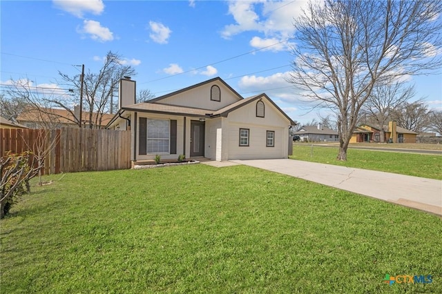 view of front of house featuring a front lawn, fence, driveway, and a chimney