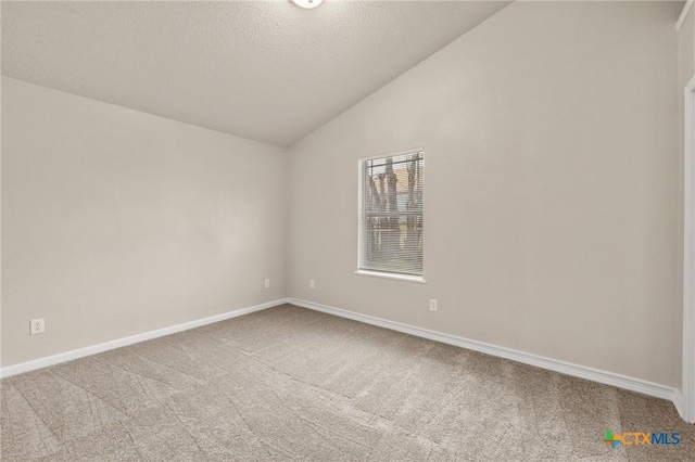 carpeted empty room with lofted ceiling, baseboards, and a textured ceiling