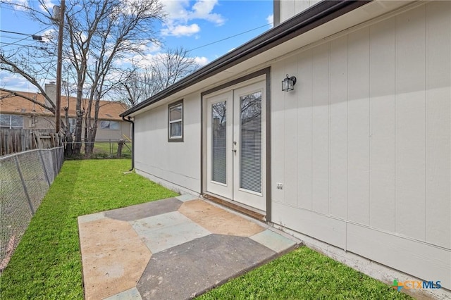 entrance to property with a patio, a yard, and fence