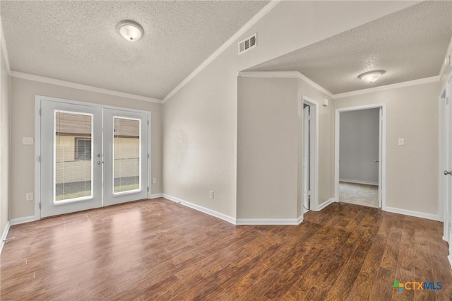 spare room with visible vents, ornamental molding, french doors, and wood finished floors