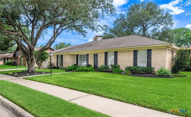 401 Hampshire St, Victoria, TX 77904 - single story home with brick siding, a front lawn, and a chimney