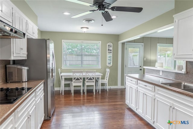 401 Hampshire St, Victoria, TX 77904 - kitchen featuring black electric stovetop, a ceiling fan, white cabinetry, wall chimney range hood, and dark wood-type flooring
