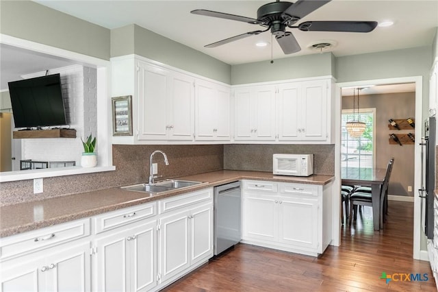 401 Hampshire St, Victoria, TX 77904 - kitchen featuring stainless steel dishwasher, white microwave, and white cabinets