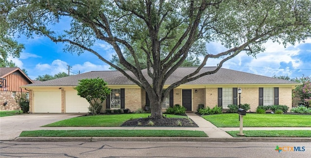 401 Hampshire St, Victoria, TX 77904 - single story home featuring a front yard, an attached garage, driveway, and brick siding