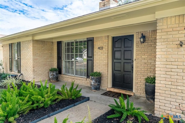 401 Hampshire St, Victoria, TX 77904 - property entrance featuring brick siding, a chimney, and covered porch