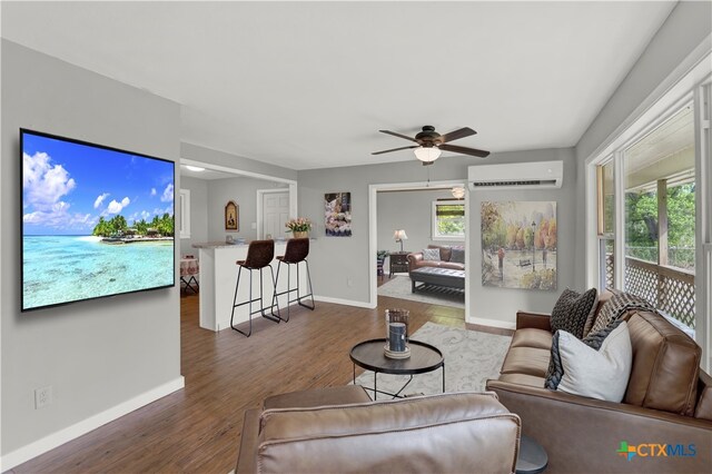 1210 Old Martindale Rd, San Marcos, TX 78666 - living room featuring baseboards, wood finished floors, a ceiling fan, and a wall unit AC