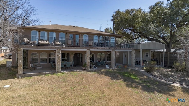 back of property with stucco siding, a patio, a balcony, and a yard