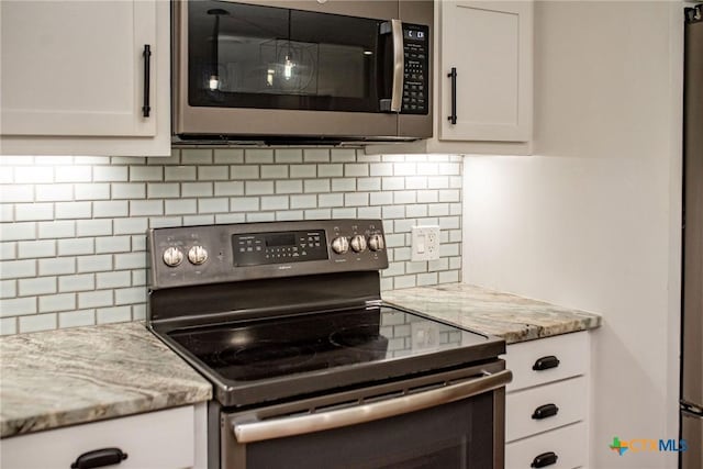 248 Park Rd, Port Lavaca, TX 77979 - kitchen with appliances with stainless steel finishes, decorative backsplash, and white cabinetry