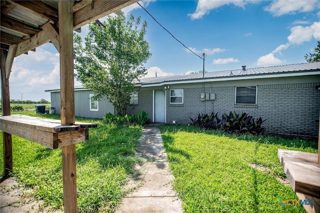248 Park Rd, Port Lavaca, TX 77979 - view of front facade with brick siding, a front yard, and metal roof