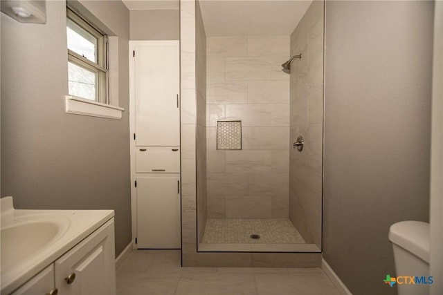 248 Park Rd, Port Lavaca, TX 77979 - bathroom featuring a tile shower, vanity, toilet, and baseboards