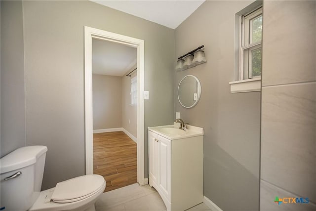 248 Park Rd, Port Lavaca, TX 77979 - half bath featuring toilet, baseboards, vanity, and wood finished floors