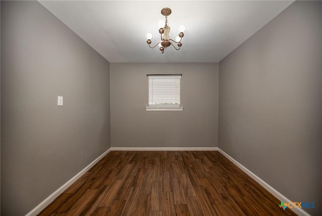 248 Park Rd, Port Lavaca, TX 77979 - unfurnished room with a chandelier, baseboards, and dark wood-type flooring