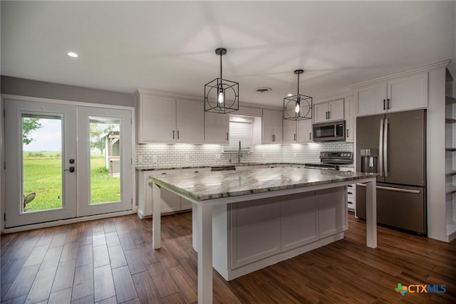 248 Park Rd, Port Lavaca, TX 77979 - kitchen with appliances with stainless steel finishes, white cabinets, french doors, a kitchen island, and backsplash