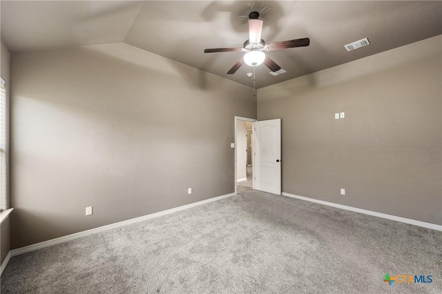 spare room featuring visible vents, baseboards, a ceiling fan, carpet, and vaulted ceiling