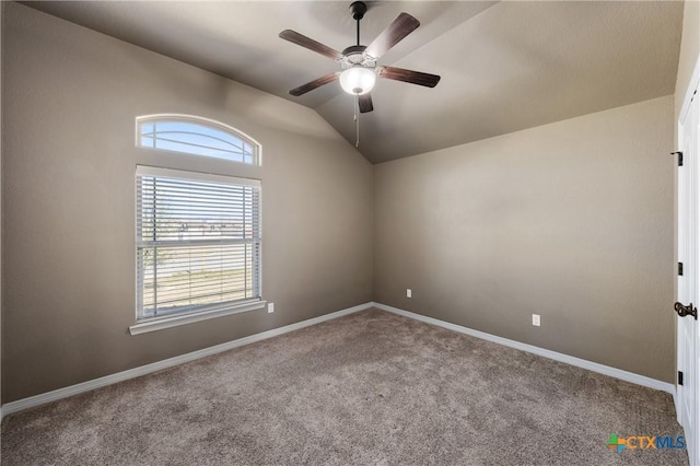 empty room featuring ceiling fan, carpet, baseboards, and vaulted ceiling