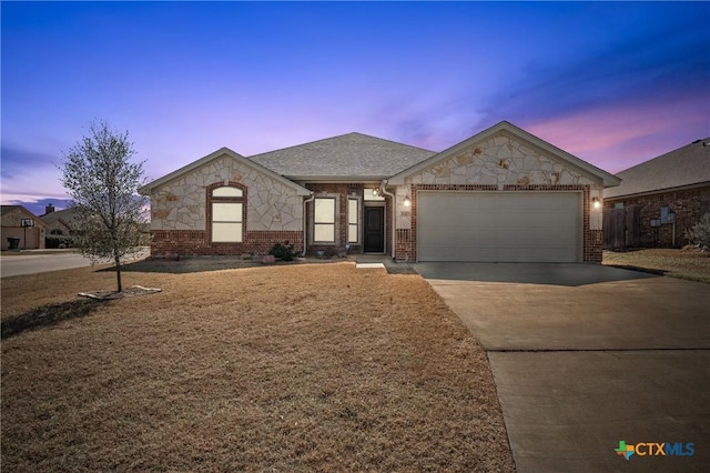 view of front of home with concrete driveway, stone siding, roof with shingles, an attached garage, and brick siding