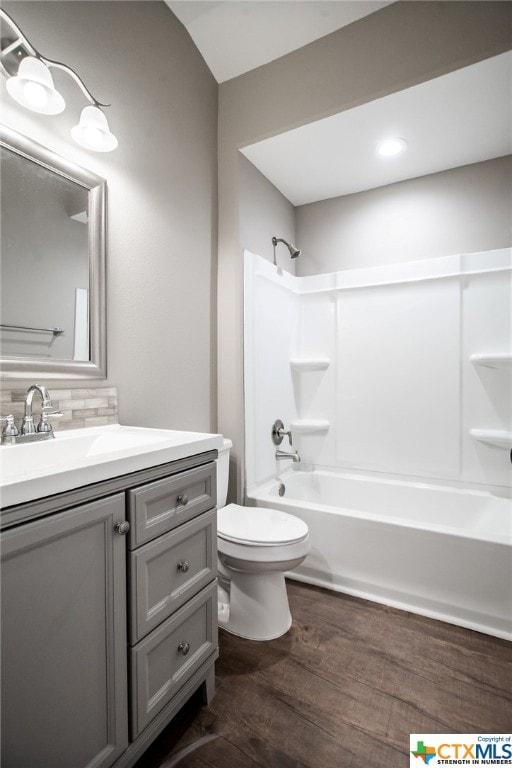 full bathroom featuring  shower combination, hardwood / wood-style flooring, vanity, and toilet