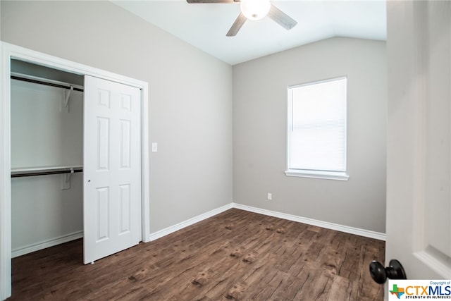 unfurnished bedroom with dark hardwood / wood-style flooring, ceiling fan, vaulted ceiling, and a closet