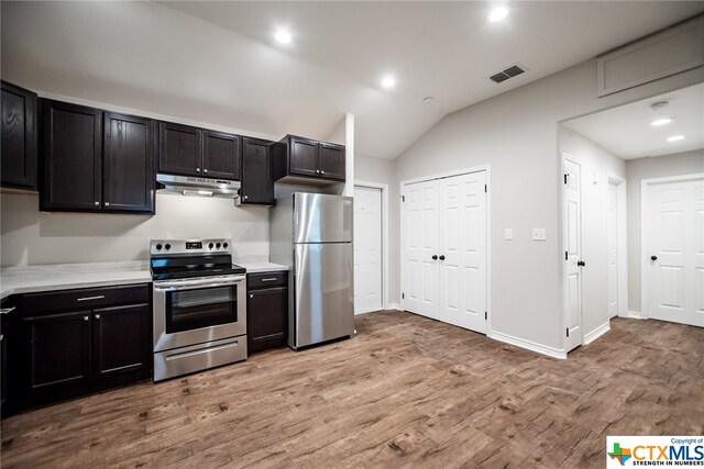 kitchen featuring vaulted ceiling, light hardwood / wood-style floors, and stainless steel appliances