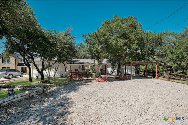 view of front of home with gravel driveway, fence, and a carport
