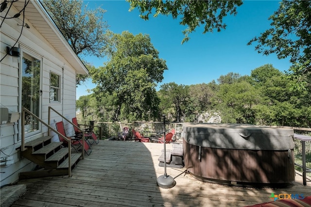 deck featuring a hot tub and entry steps