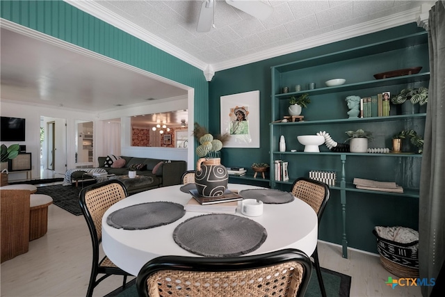 dining area featuring built in shelves, ornamental molding, a ceiling fan, and wood finished floors