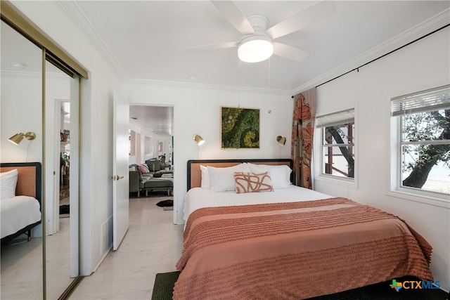 bedroom featuring crown molding, a ceiling fan, and a closet