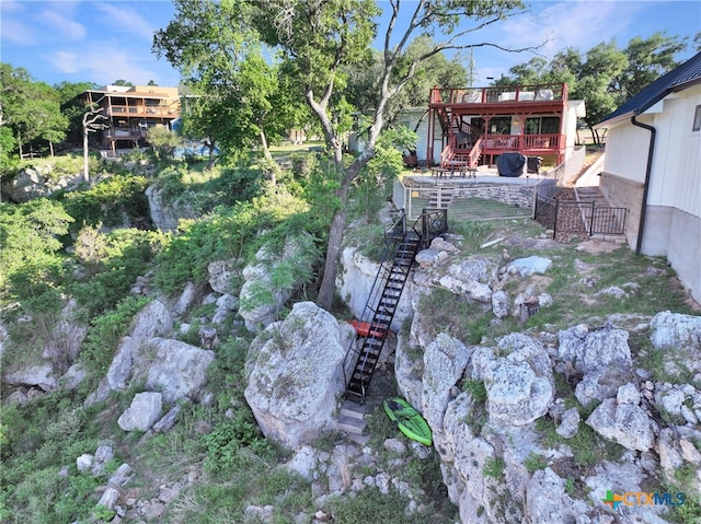 view of yard with a deck, fence, and stairs