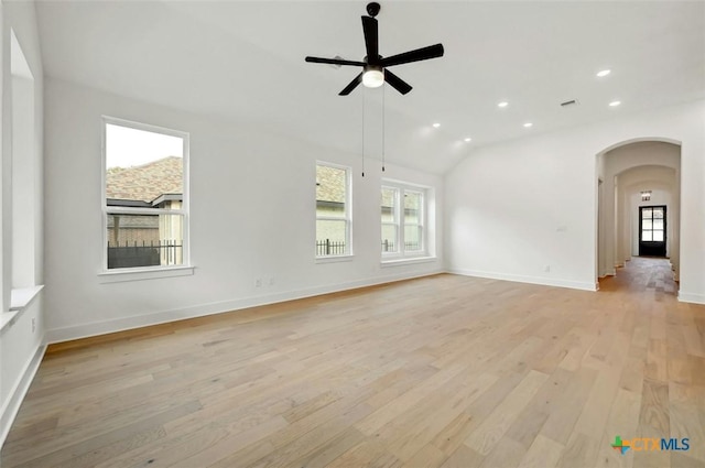 empty room with vaulted ceiling, ceiling fan, and light hardwood / wood-style floors