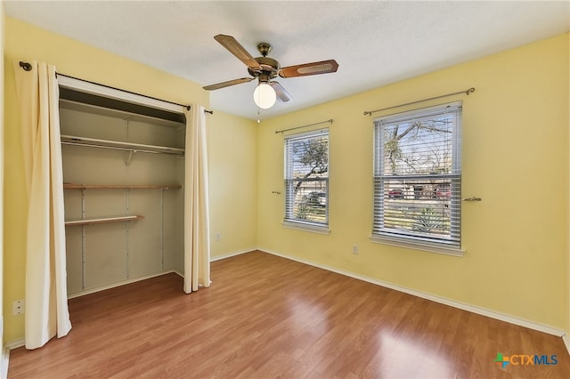 unfurnished bedroom with a closet, baseboards, and wood finished floors