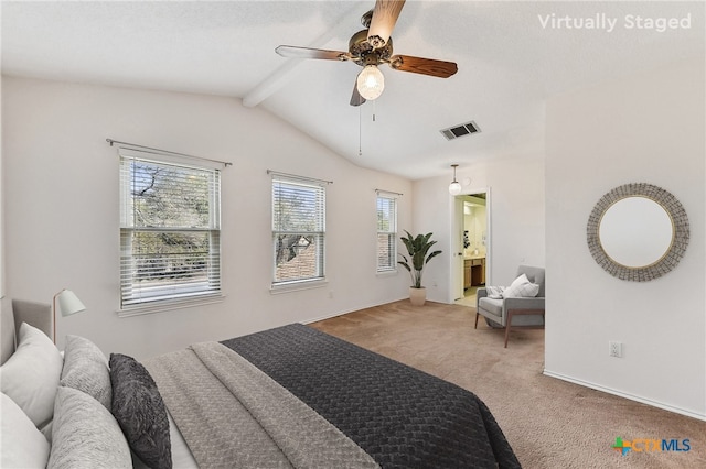 carpeted bedroom with visible vents, baseboards, lofted ceiling with beams, ensuite bath, and a ceiling fan