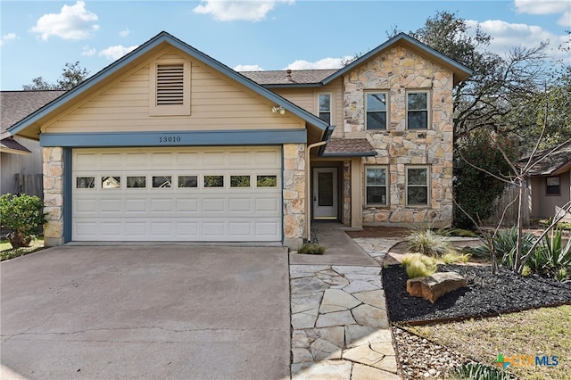 view of front of home featuring stone siding, concrete driveway, and a garage