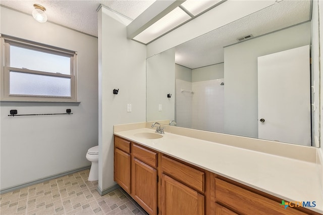 full bathroom featuring vanity, a textured ceiling, visible vents, walk in shower, and toilet