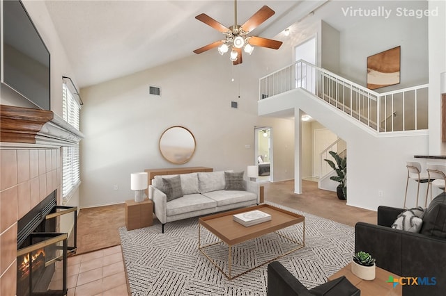 living room with stairway, a fireplace, visible vents, and light carpet