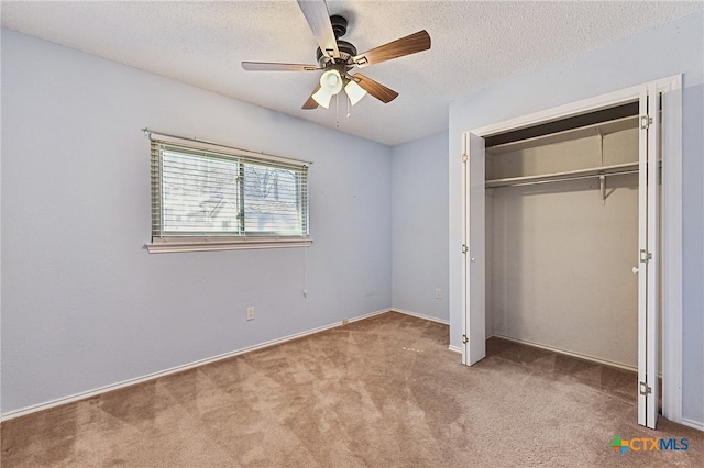 unfurnished bedroom with a closet, a textured ceiling, ceiling fan, and carpet flooring