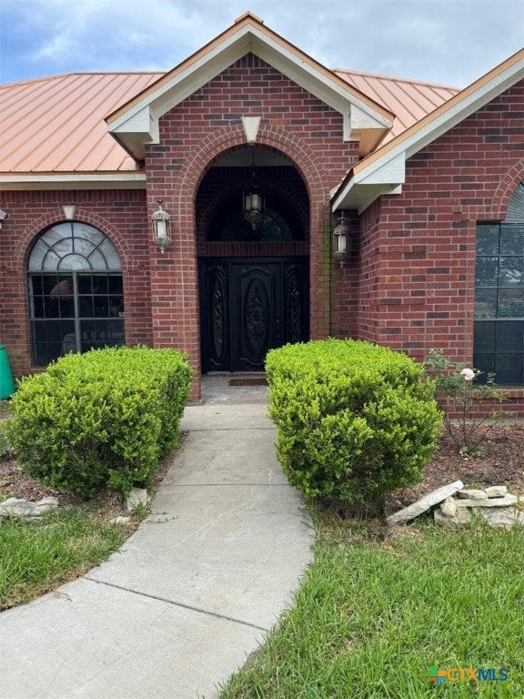 507 Hackberry Bnd, Port Lavaca, TX 77979 - doorway to property featuring a standing seam roof, metal roof, and brick siding