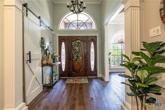 507 Hackberry Bnd, Port Lavaca, TX 77979 - foyer with a barn door, ornamental molding, wood finished floors, a towering ceiling, and a chandelier