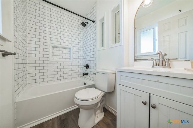 full bathroom featuring toilet, tiled shower / bath combo, vanity, and hardwood / wood-style flooring