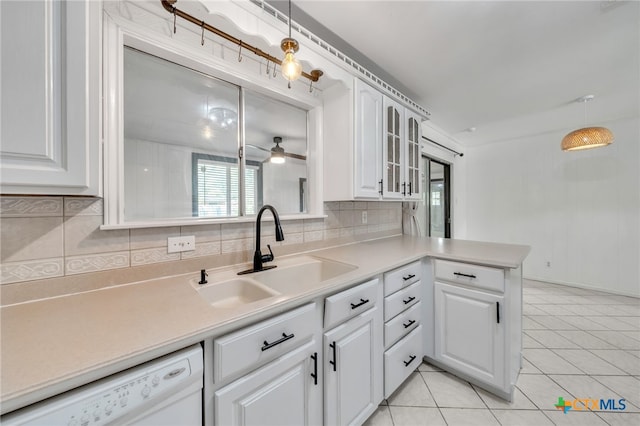 kitchen featuring white cabinets, decorative backsplash, hanging light fixtures, and sink