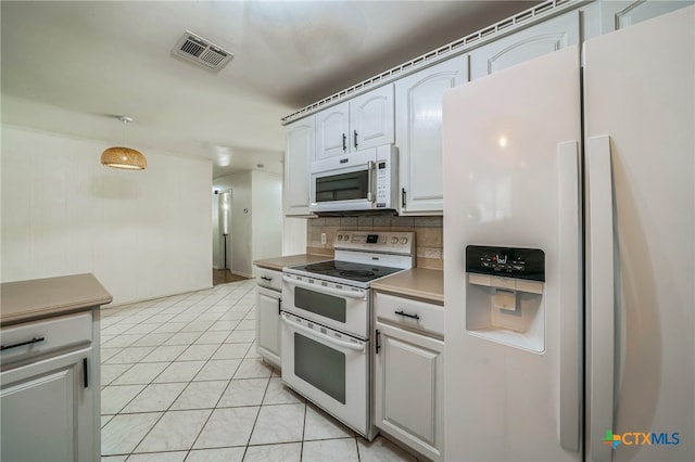 kitchen featuring light tile patterned flooring, white cabinetry, backsplash, white appliances, and pendant lighting